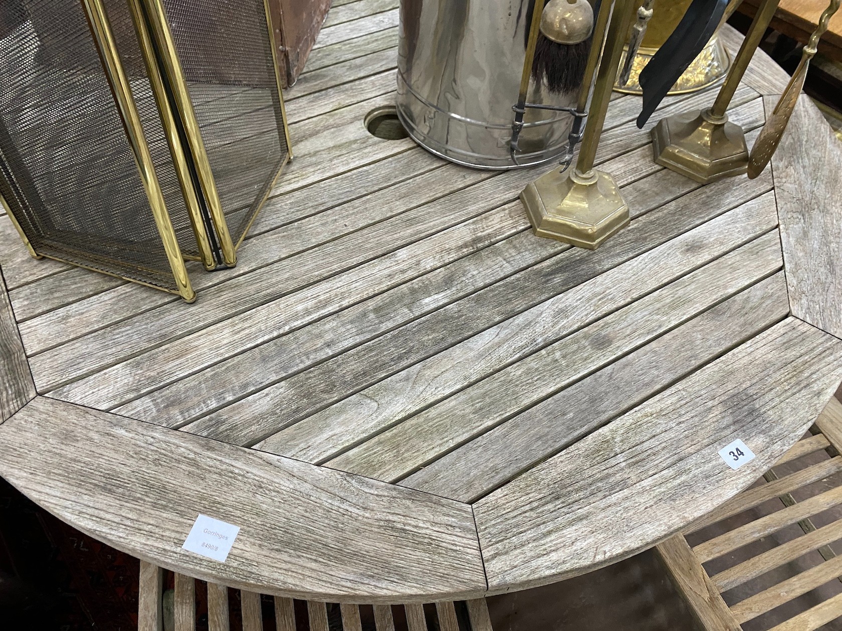 A Gloster weathered teak circular garden table, diameter 130cm, height 70cm and four folding chairs